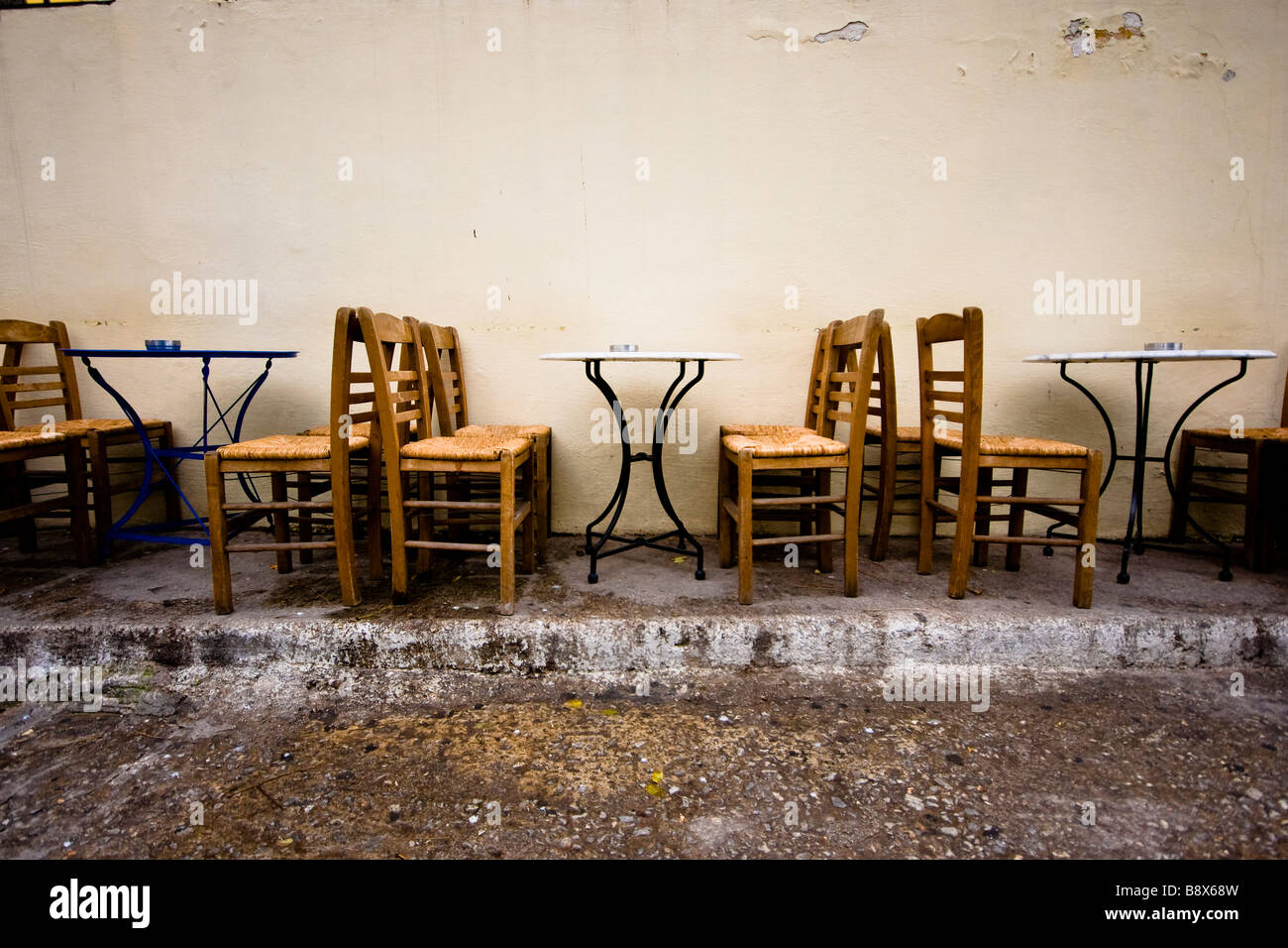 Empty chairs and tables against the wall in Athens Stock Photo Alamy
