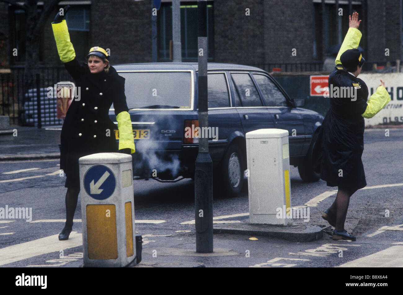 Traffic Wardens on duty central London UK. Stopping traffic at a pedestrian crossing  1985 1980s England HOMER SYKES Stock Photo