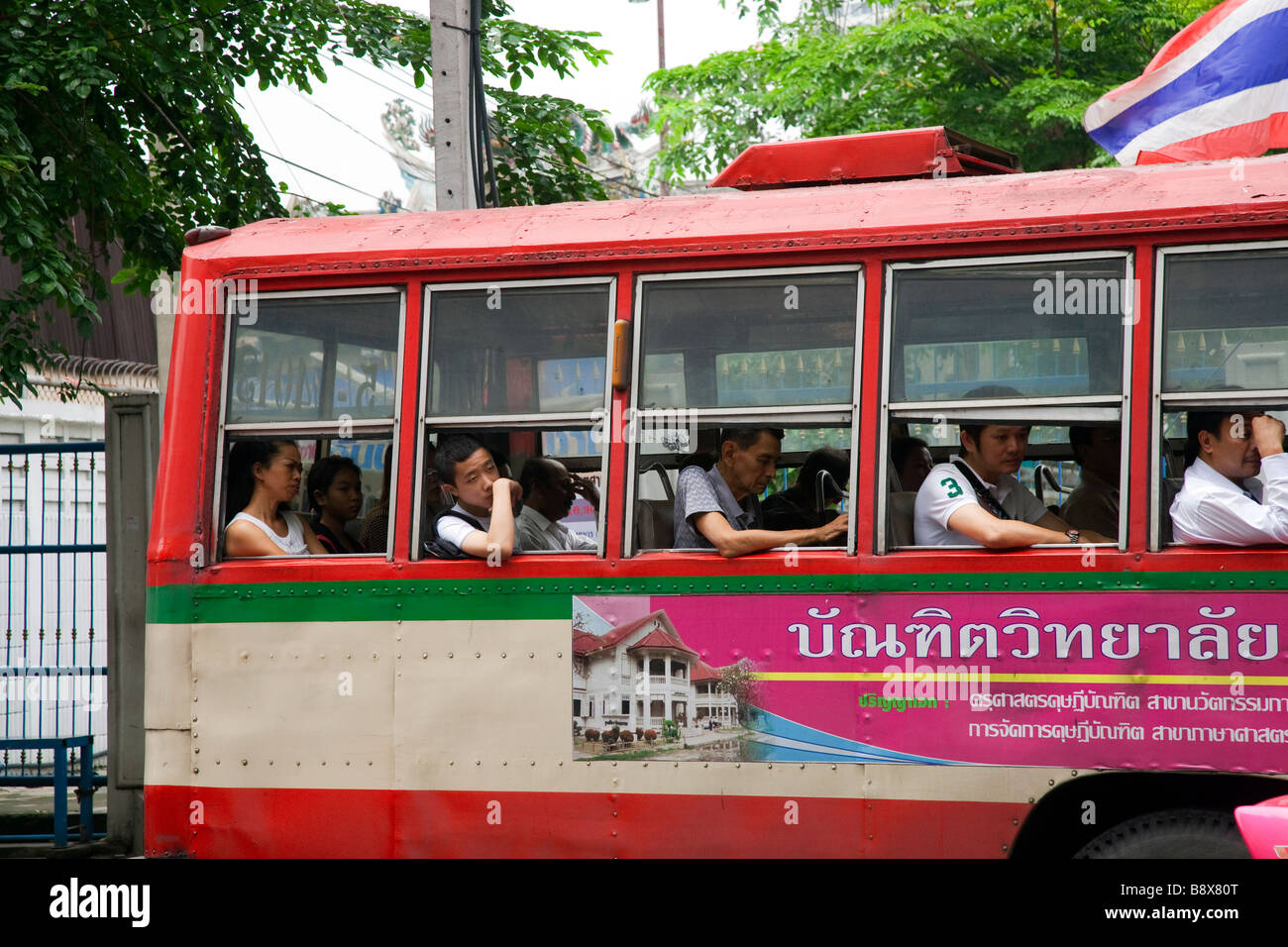 Passengers seated in open window Bus in Bangkok City, Thailand Stock