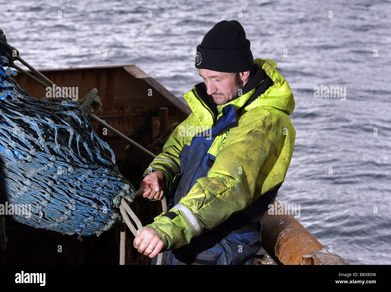 North sea fisherman based in Peterhead, Scotland, working on the nets of a fishing boat Stock Photo