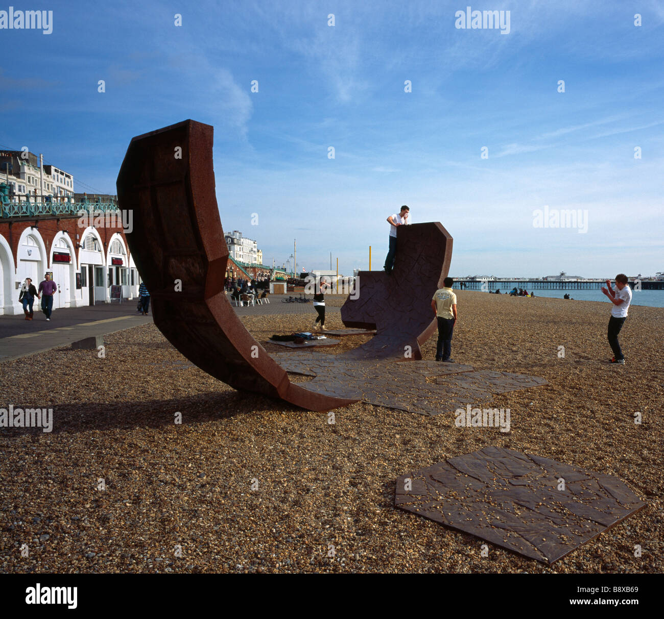 Teenagers playing on a modern art sculpture called Passacaglia. Brighton Beach, Sussex, England, UK. Stock Photo
