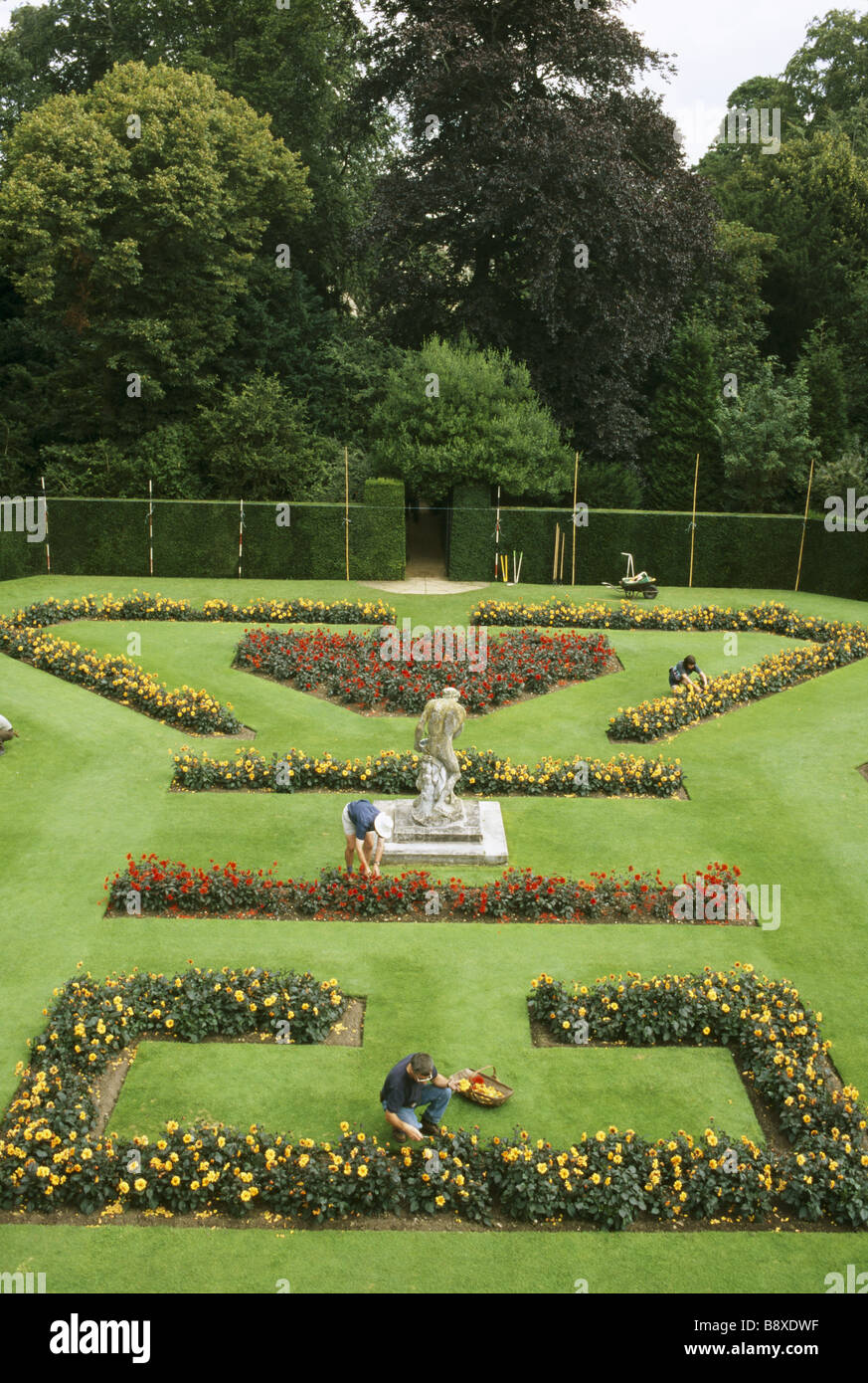 Overall view of formal garden whilst gardeners deadheading the flowers MODEL RELEASED Stock Photo