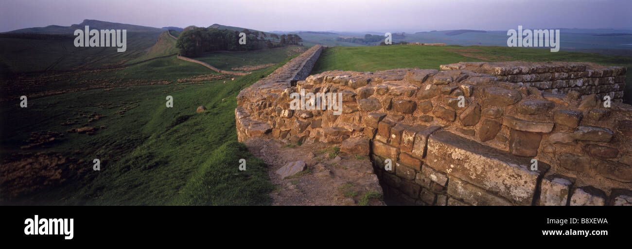 Houseteads Roman Fort looking towards Sewing Shield Crags with Hadrian s Wall washed in a bright rose light Stock Photo