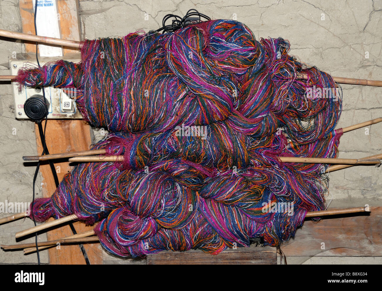 Skeins of silk thread dyed in natural colours being prepared  for weaving . Stock Photo