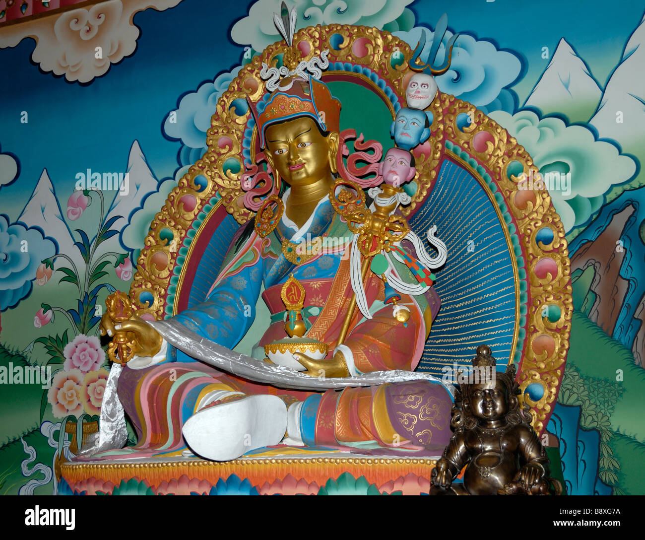 Golden image of Padmasambhava,  Guru Rinpoche holding a vajra, a skull cup and trident with three severed heads Stock Photo