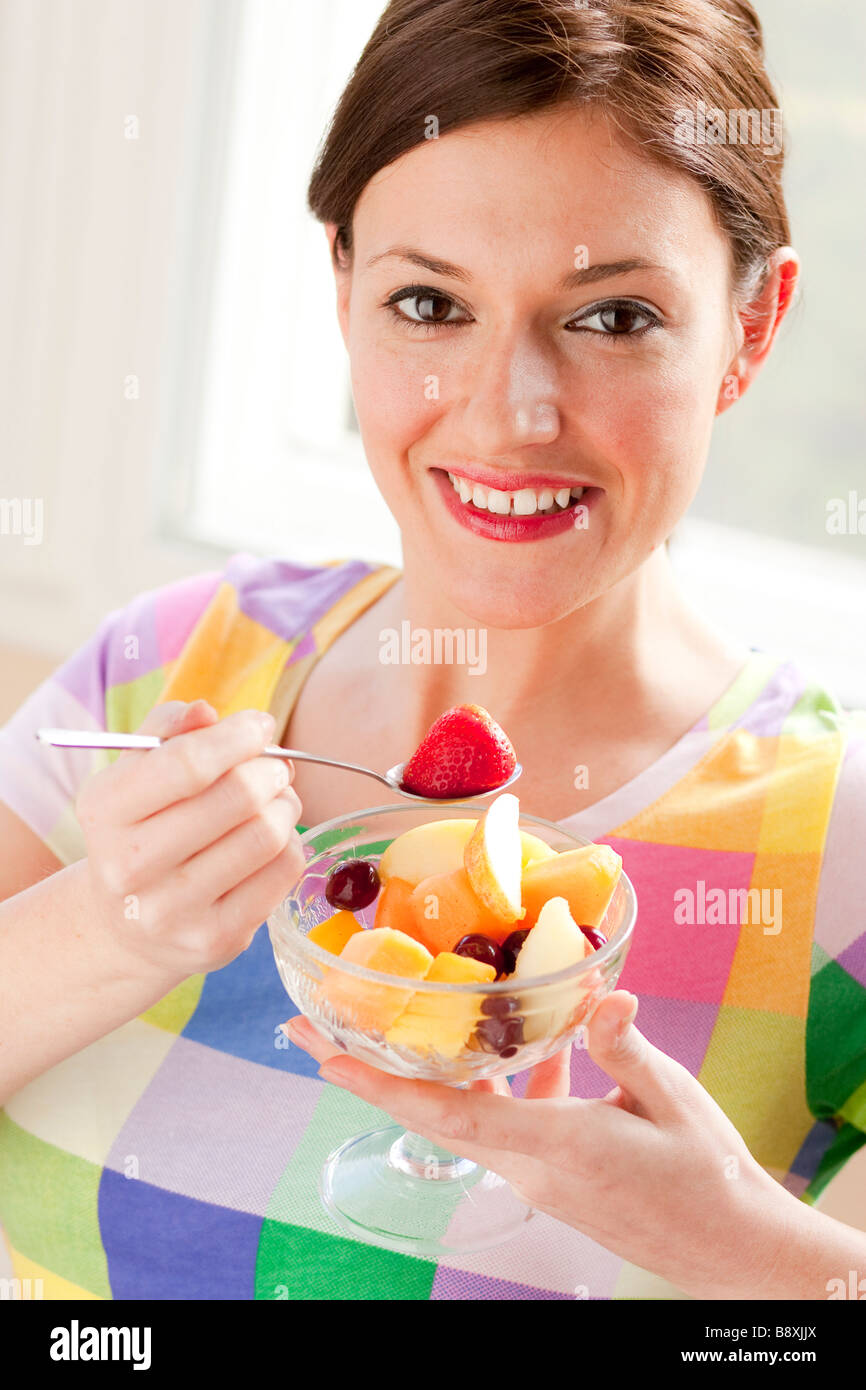 Woman eating fruit salad Stock Photo