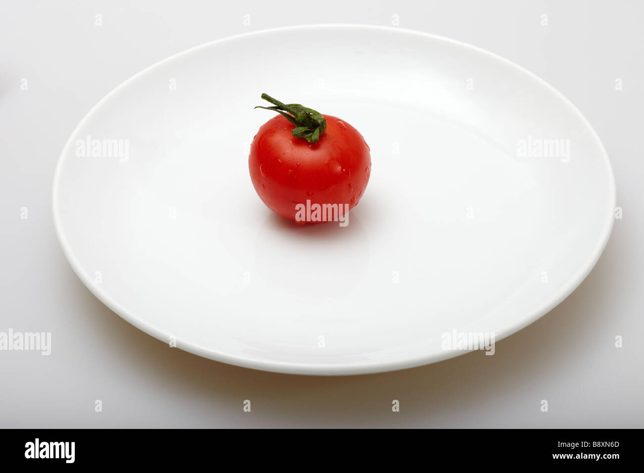 Cherry Tomato on a White Plate Stock Photo
