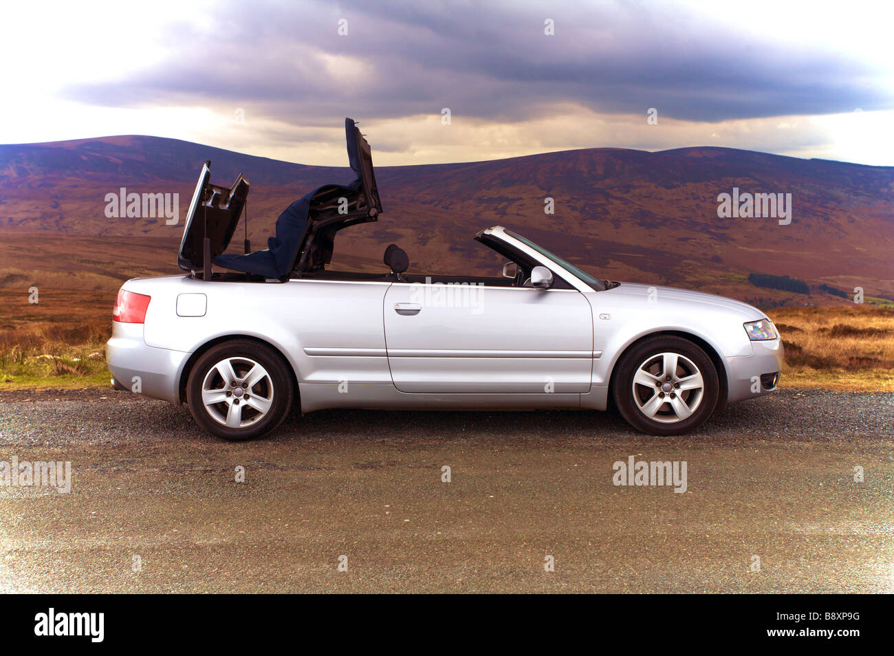 Silver Audi A4 1.8T Convertible roof coming down Stock Photo