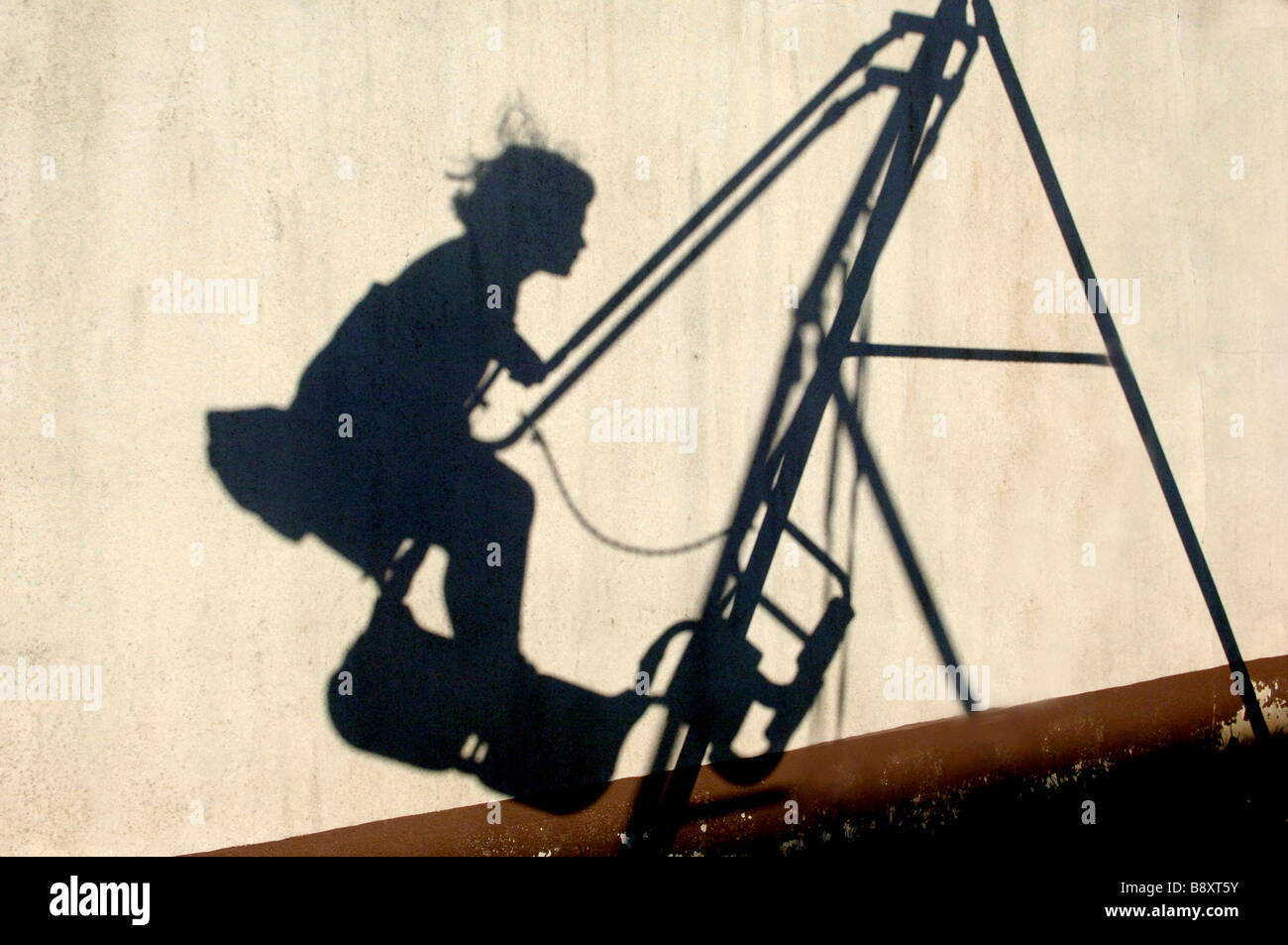 Shadow of a girl on a swing, Berlin, Germany Stock Photo
