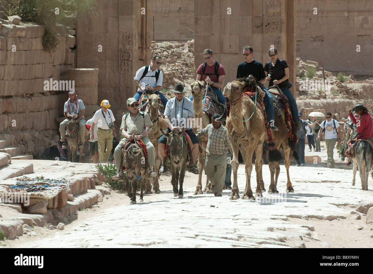 Tourists riding camels and donkeys in Petra Jordan Stock Photo Alamy