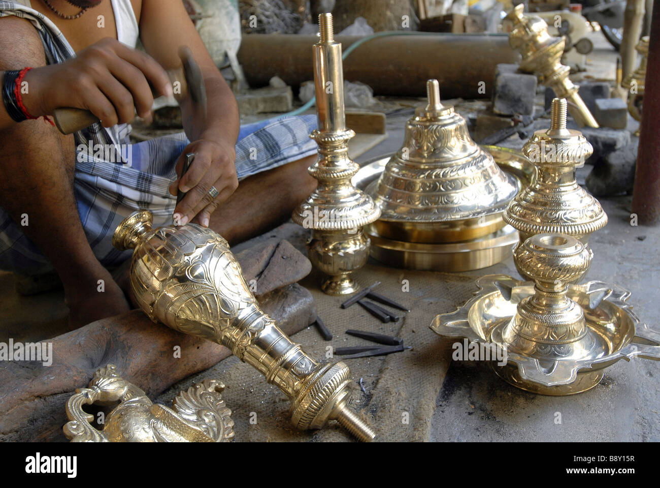 Low section view of a man making bronze oil lamps, Nachiyarkovil, Tamil