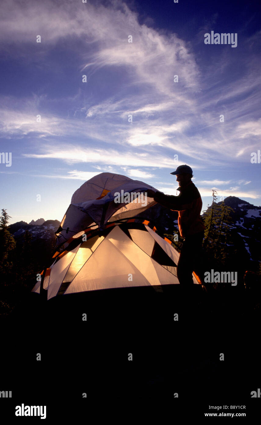 Silhouette of a man setting up a tent while hiking, Maple Pass, Washington State, USA Stock Photo