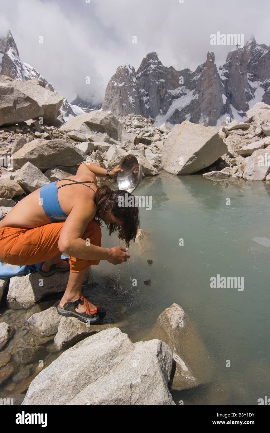 Woman washing her hair in a pond, Biafo Glacier, Karakoram Range, Baltistan, Pakistan Stock Photo