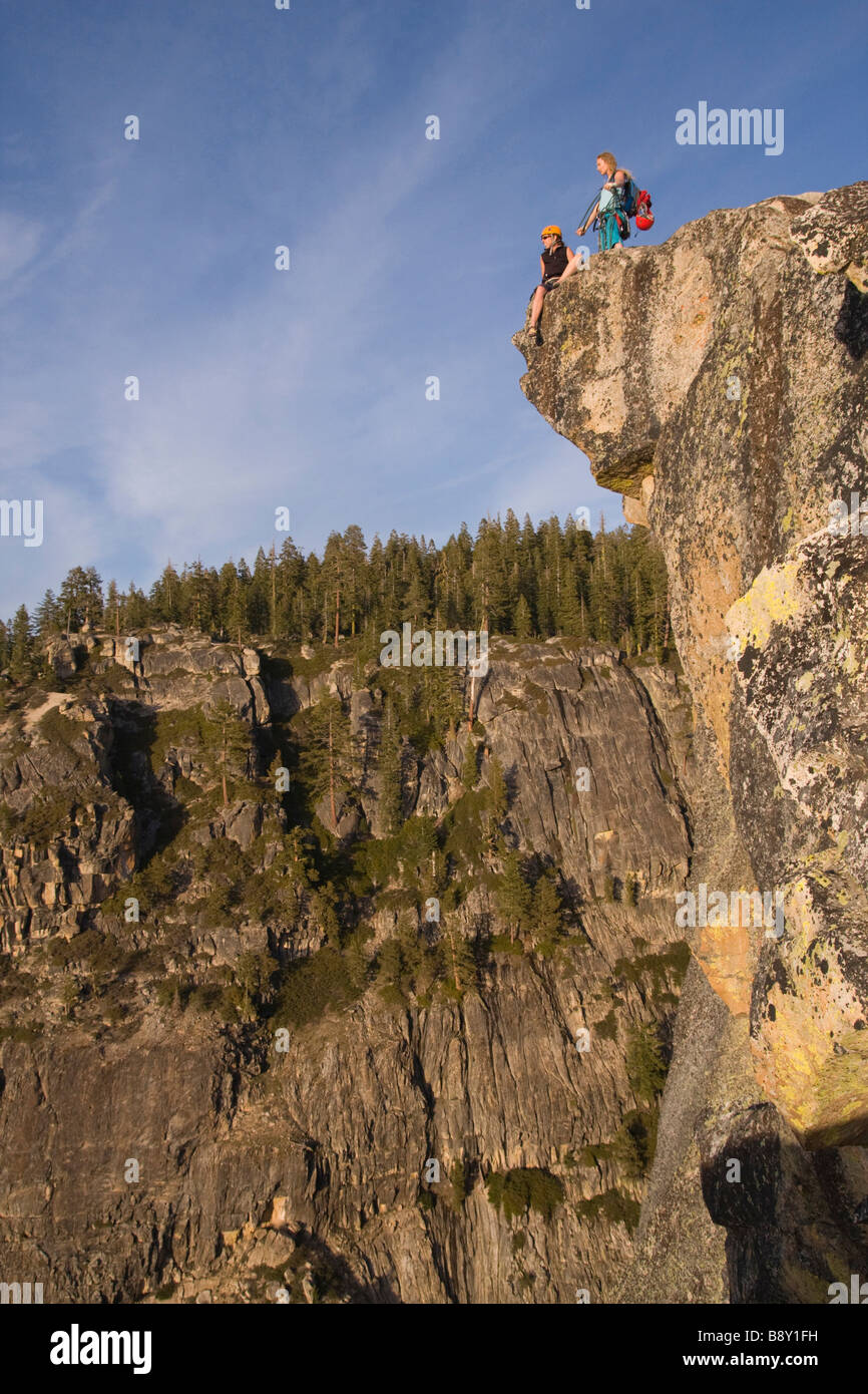 Low angle view of two female rock climbers on an overhanging cliff, Taft Point, Yosemite National Park, California, USA Stock Photo