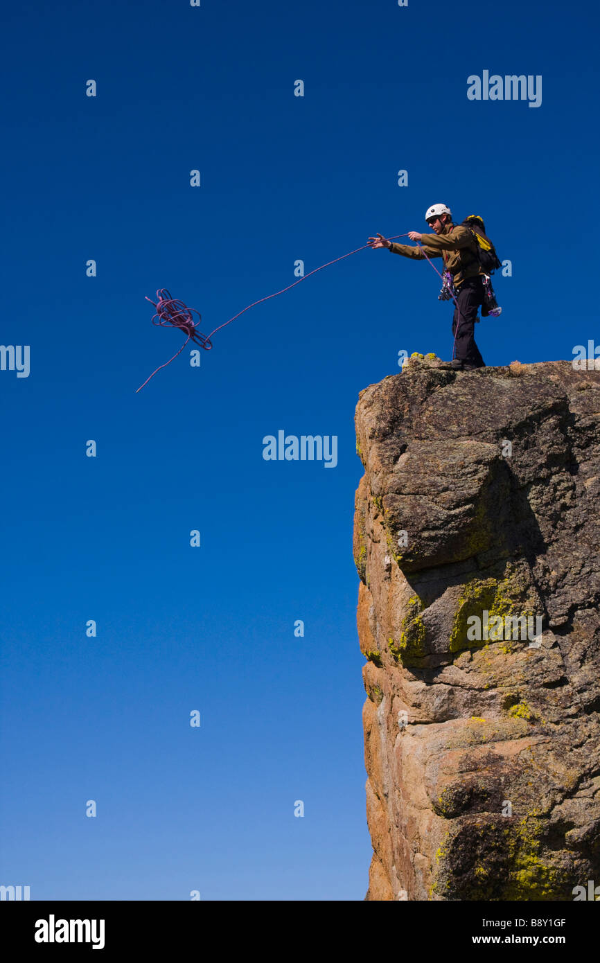 Mountaineer throwing a climbing rope off a cliff, Lake Tahoe, Nevada, USA Stock Photo