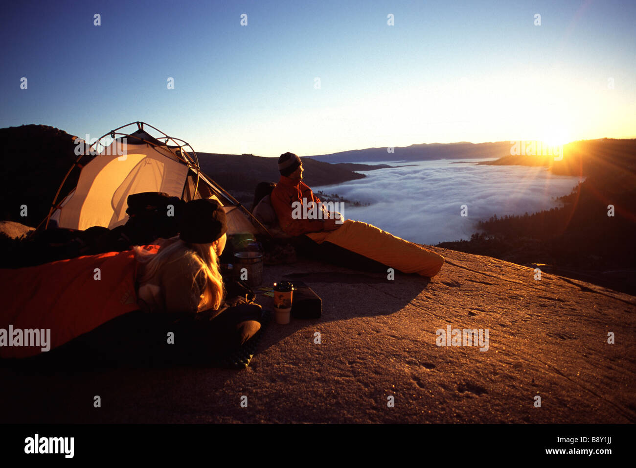 Couple watching sunrise while camping at the lakeside, Donner Lake, Truckee, Nevada County, California, USA Stock Photo