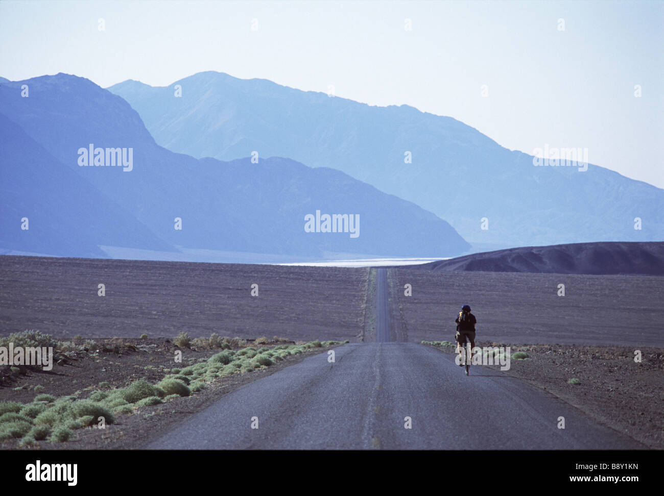 Man cycling on a highway, Death Valley, California, USA Stock Photo