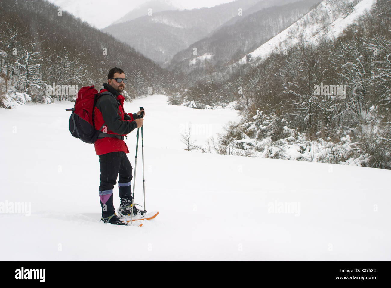 mountaineer with snowshoes in winter in a snowcapped mountains