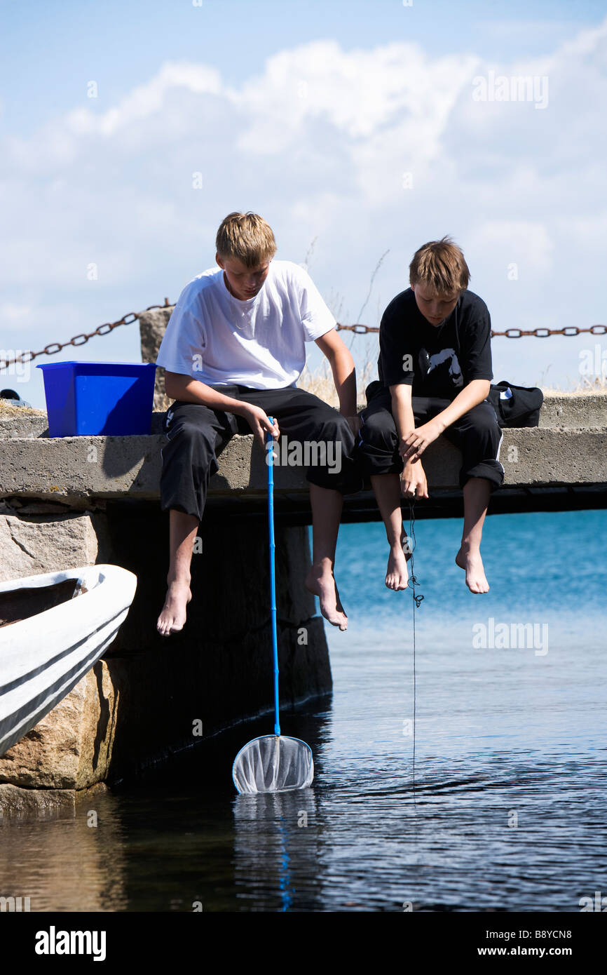 Two boys fishing crabs Smogen Bohuslan Sweden. Stock Photo