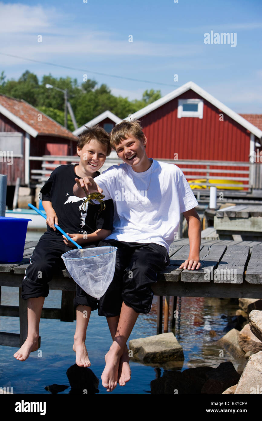 Two boys fishing crabs Smogen Bohuslan Sweden. Stock Photo