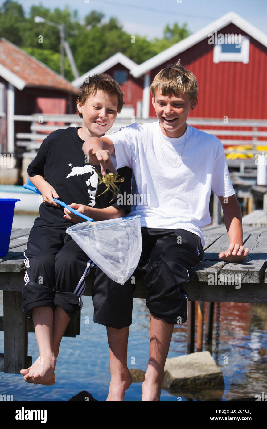 Two boys  fishing crabs Smogen Bohuslan Sweden. Stock Photo