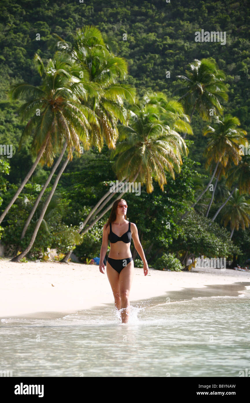 Woman walking over the paradise beach of Cane Garden Bay on the Caribbean isle of Tortola in the British Virgin Islands Stock Photo