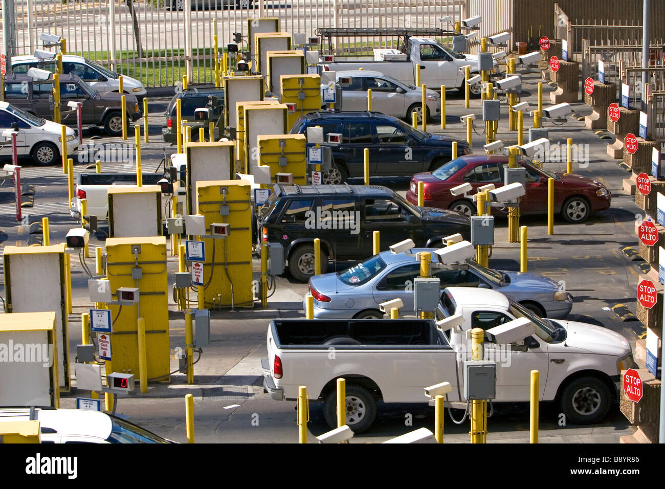 Automobiles being monitored by video cameras wait to enter the Tijuana Mexico U S San Diego California border crossing Stock Photo