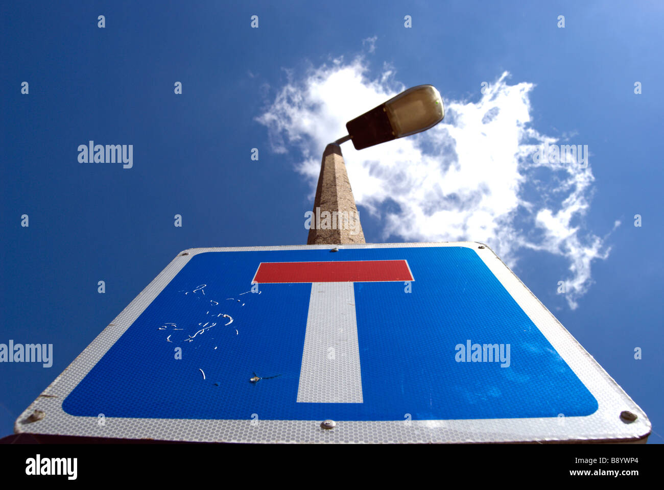 british blue and white road sign indicating a no through road, seen benath a blue sky with a single cloud Stock Photo