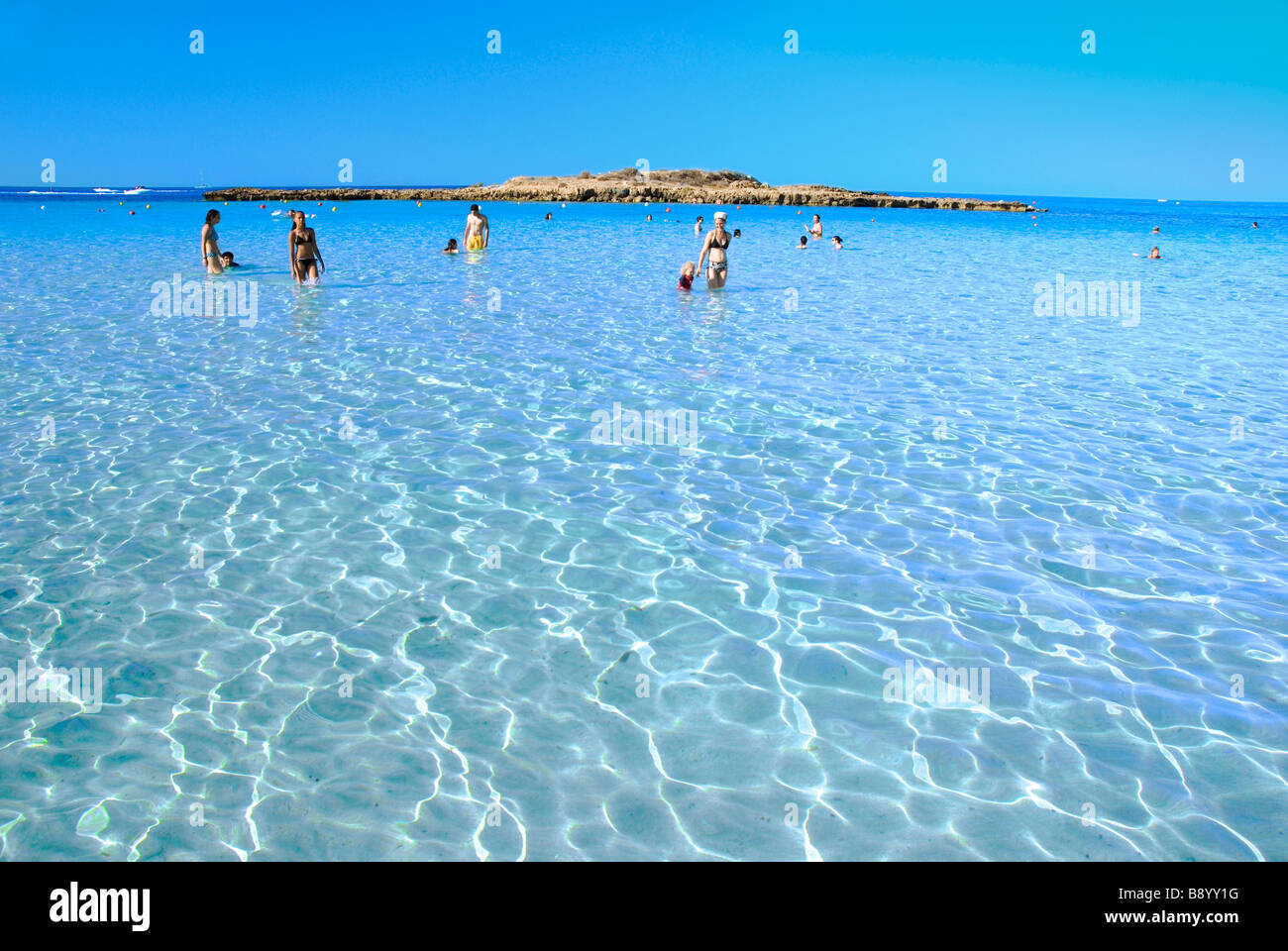The waters of the Mediterranean Sea is crystal clear by the beach in Fig Tree Bay, Protaras, Cyprus. Stock Photo