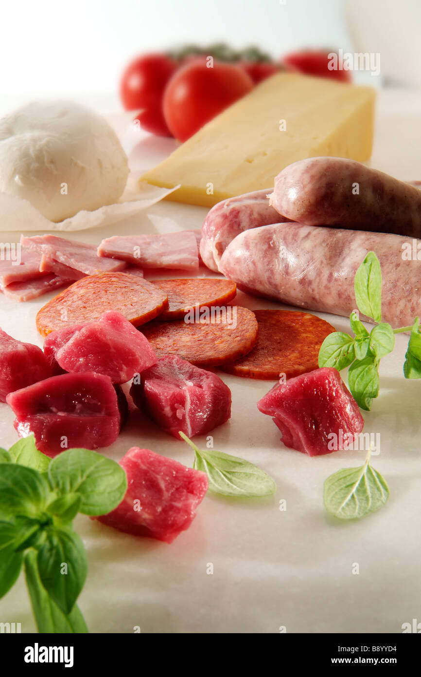 Beef Chunks Salami raw sausages ham plus buffalo mozerella Cheddar on marble Stock Photo