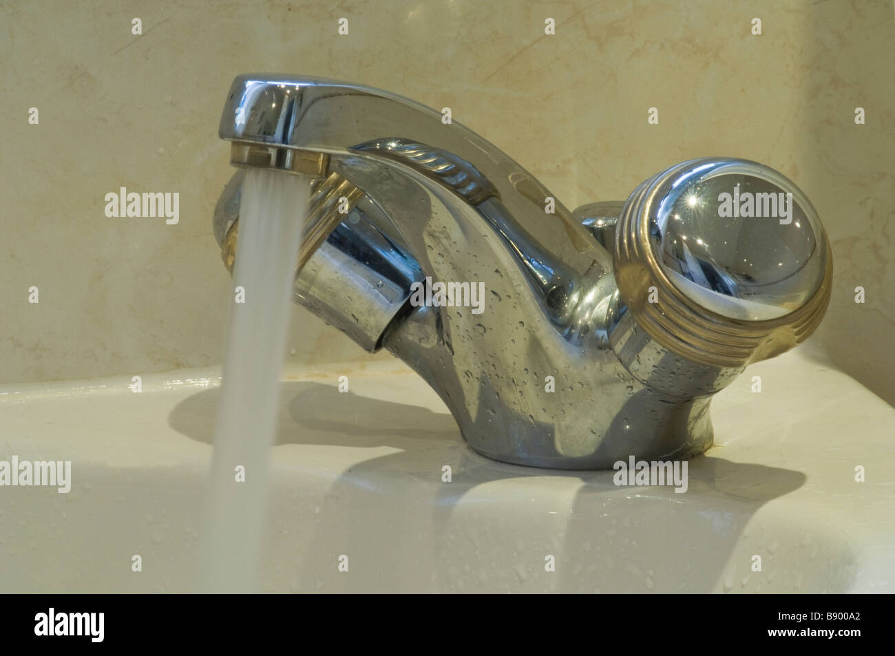 Bathroom tap with the water left running to illustrate wasting water