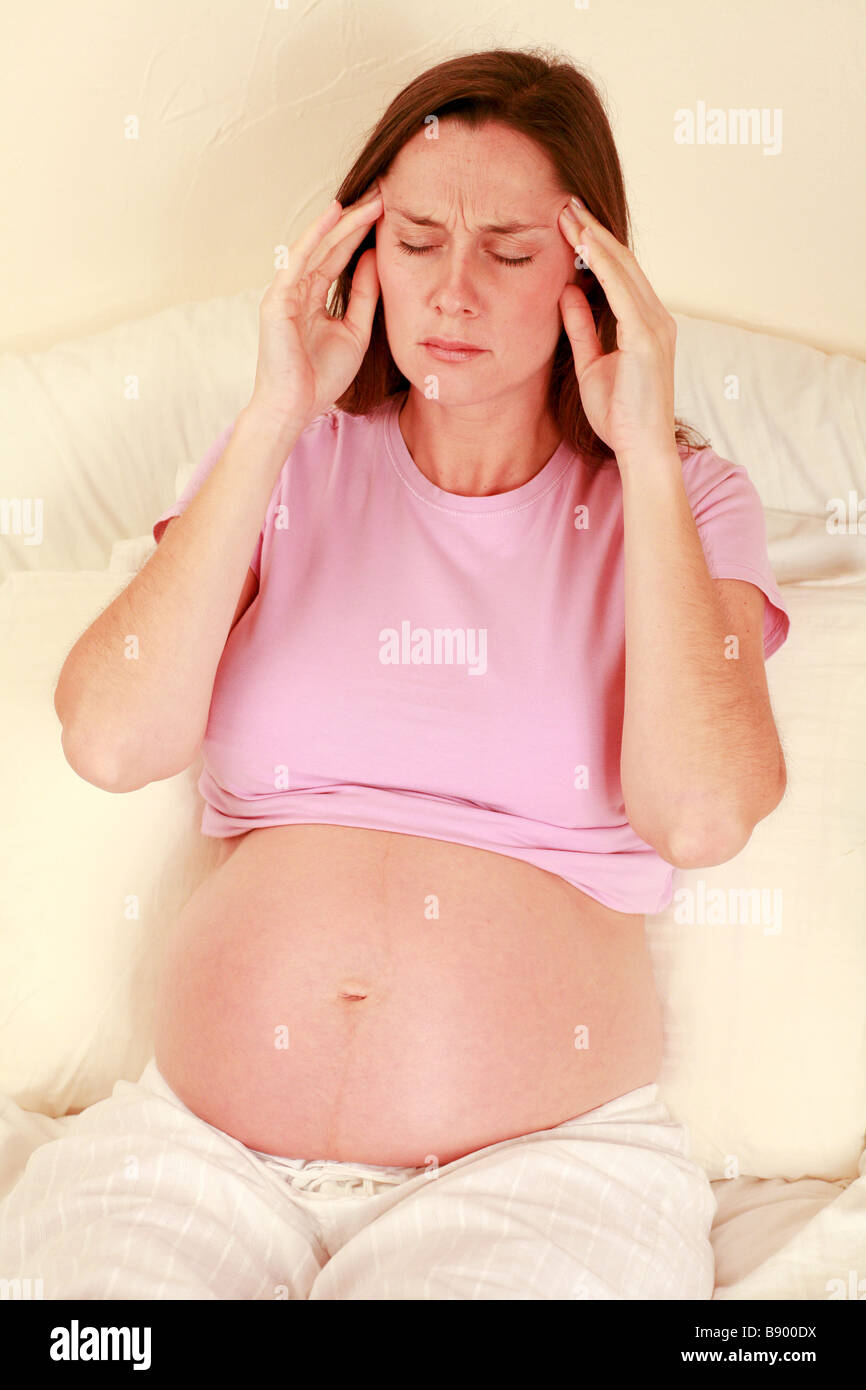 Pregnant Woman At 32 Weeks Rubs Her Temples As If She Has A Headache Stock Photo Alamy
