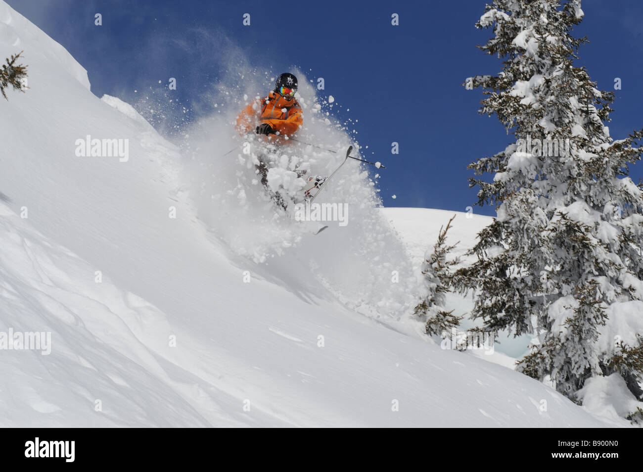 Skier jumps over a bump in deep powder Stock Photo