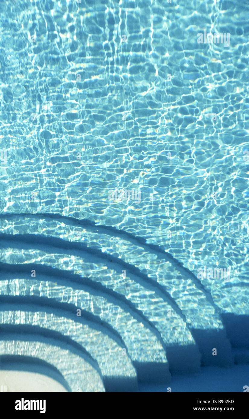 Turquoise clear blue water fills graphic shapes in a swimming pool with ...