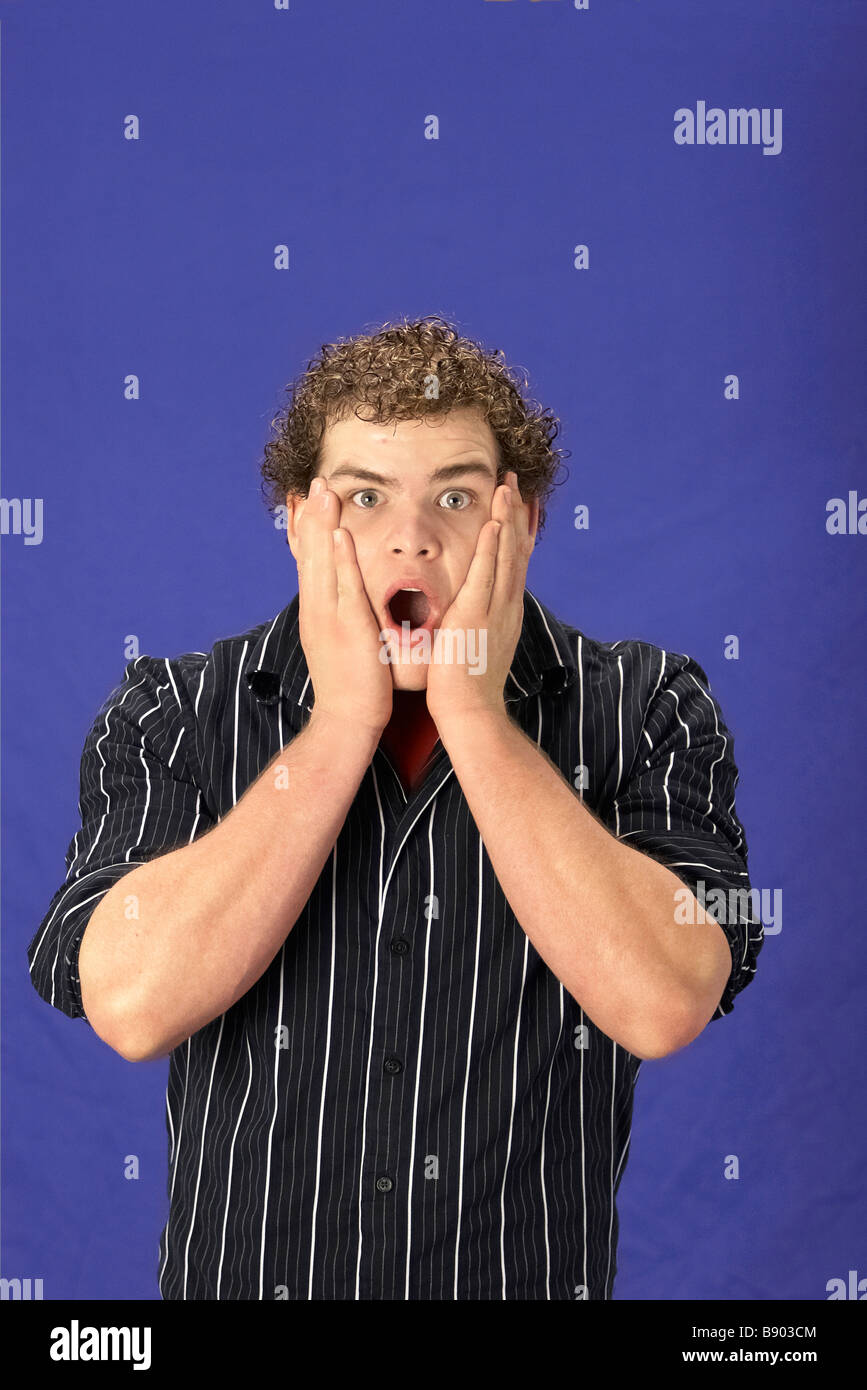 A young man alone shocked with face on hands Stock Photo