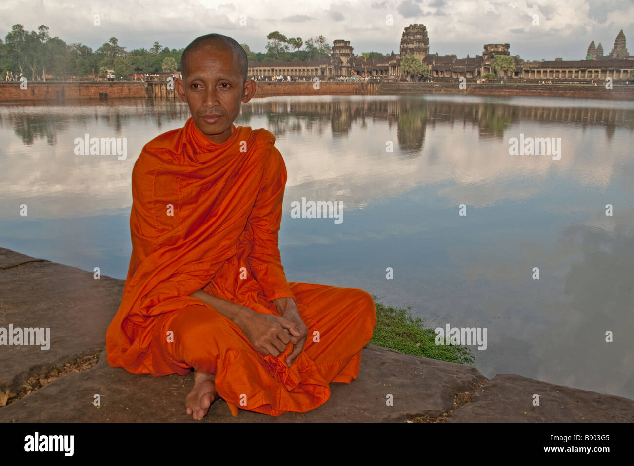 Angkor Wat monk at west entrance beside moat Stock Photo