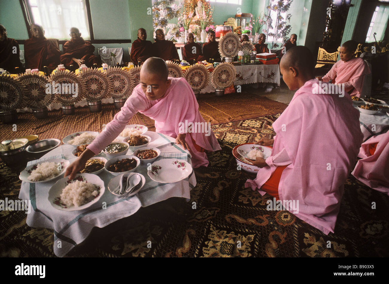 Burmese nuns preparing meal for ceremony Stock Photo