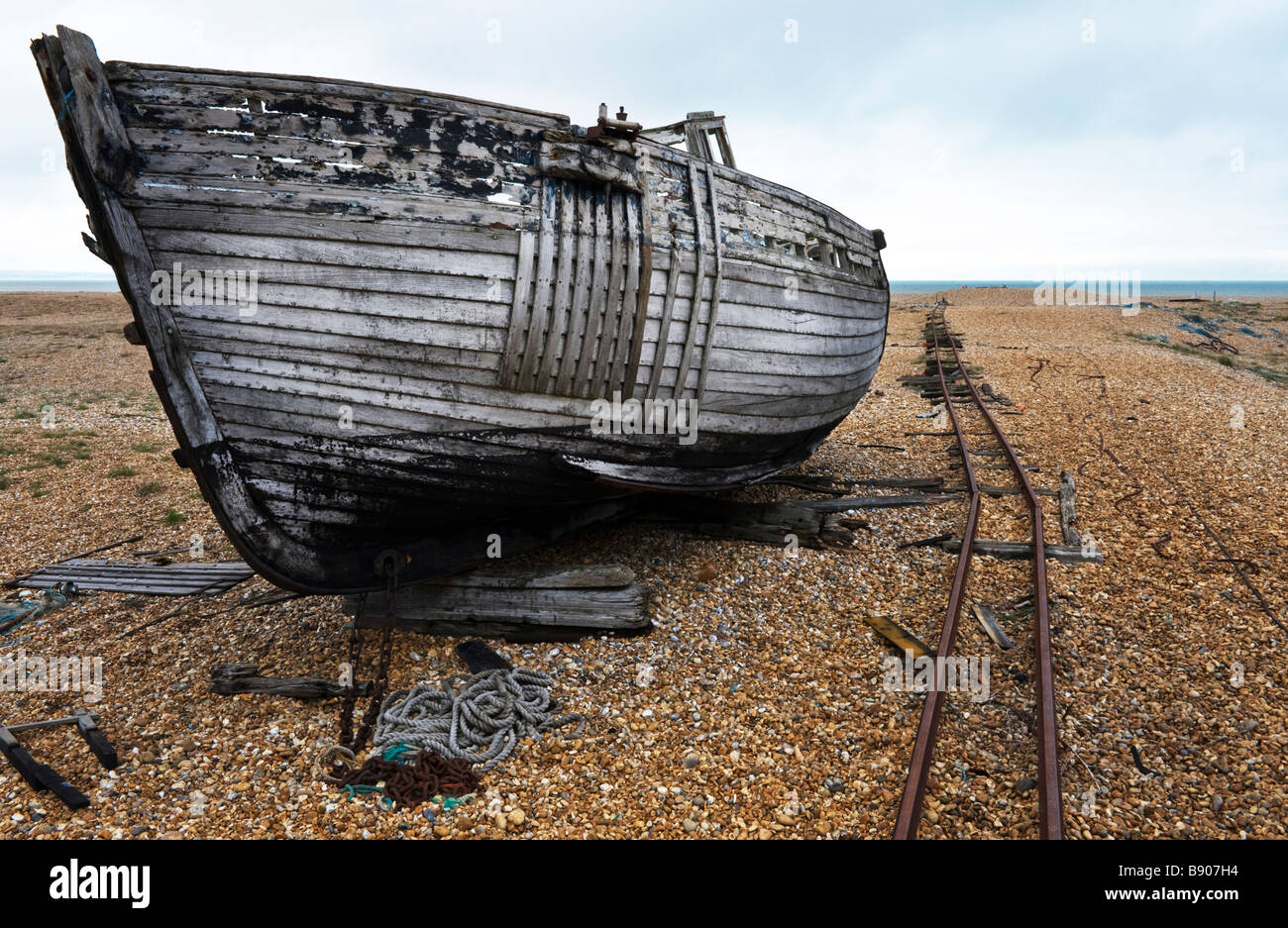 Wreckage of an abandoned fishing boat on the shingle beach at Dungeness in Kent, UK Stock Photo