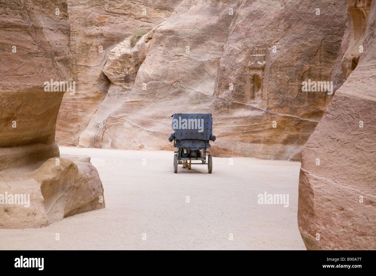 A horse and cart carriage making its way through the Siq at the entrance to Petra, Jordan Stock Photo