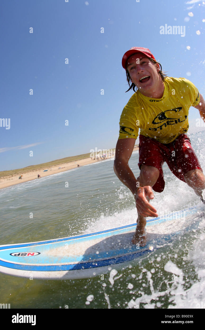 Surfer is surfing on his surfboard near Mimizan, in France. It is sunny