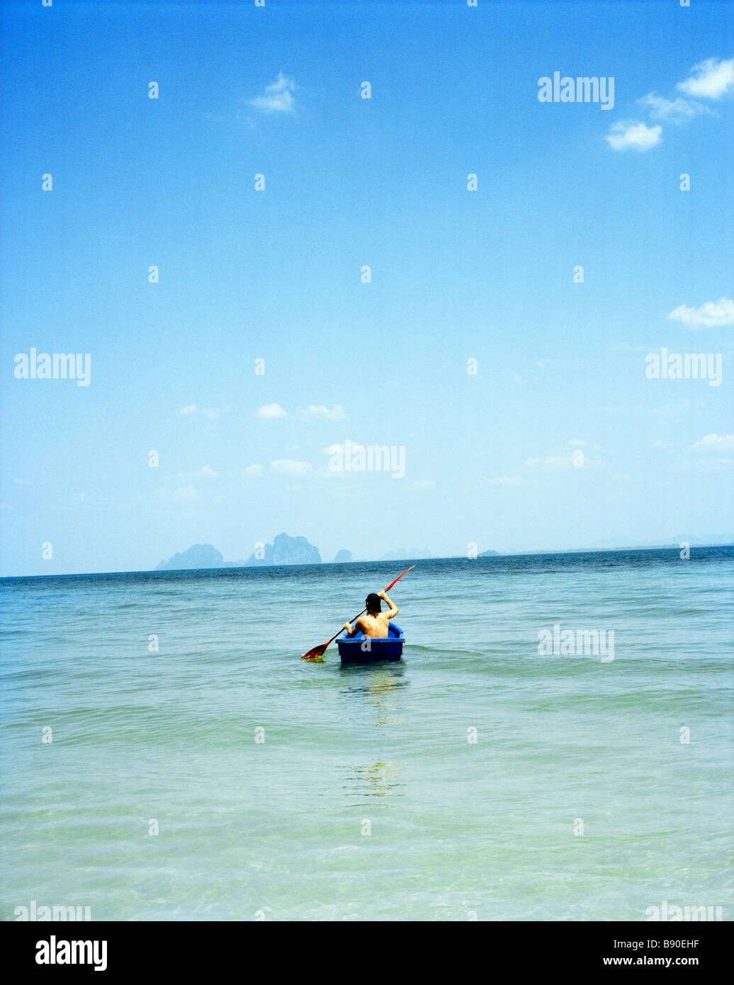 A man in a small boat on the blue sea Thailand. Stock Photo
