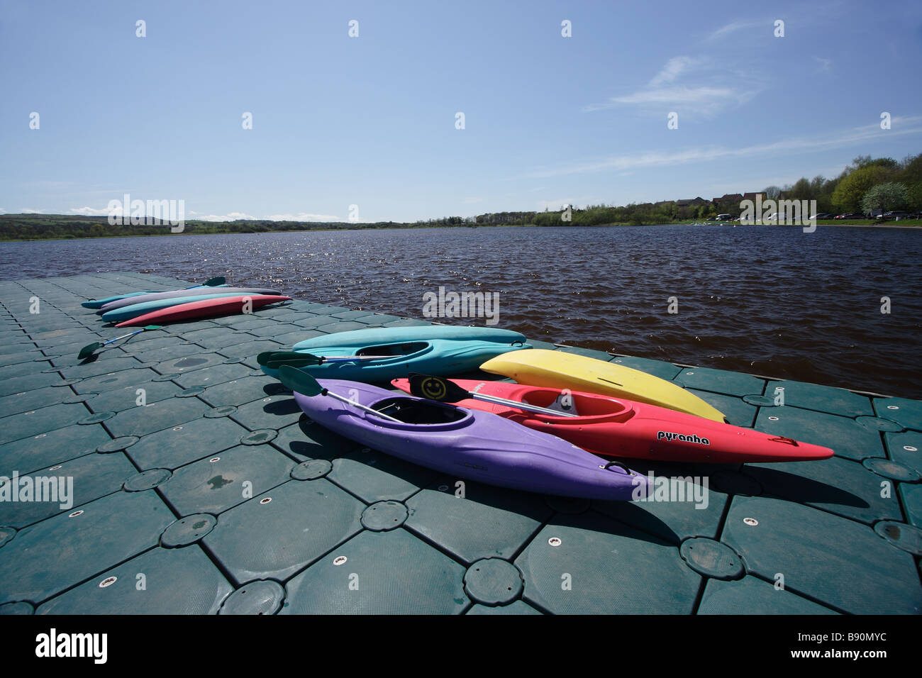 Canoes on a jetty in summer sun at Castle Semple Loch, Clyde Muirshiel Regional Park, Lochwinnoch, Renfrewshire, Scotland UK Stock Photo