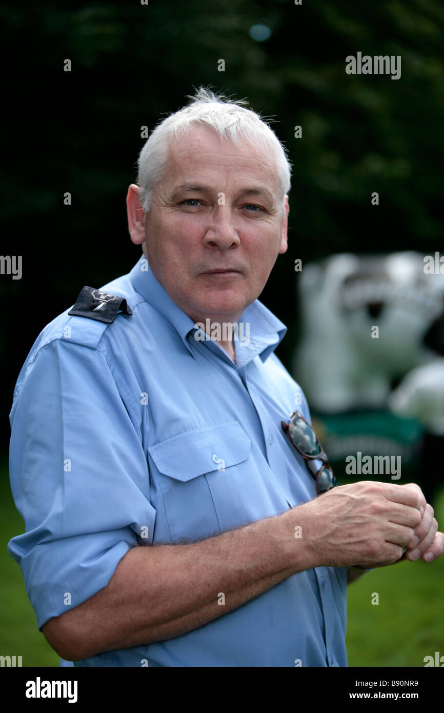 A park warden enjoys some ice cream in the park Stock Photo