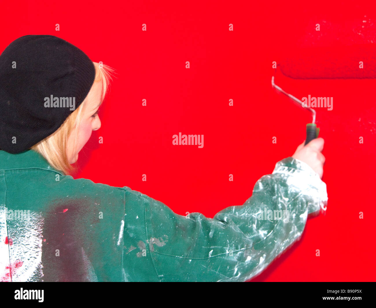 young girl painting a wall red with a roller Stock Photo Alamy
