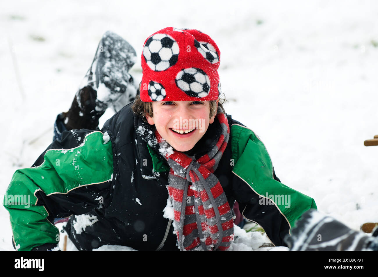 smiling boy playing in the snow Stock Photo