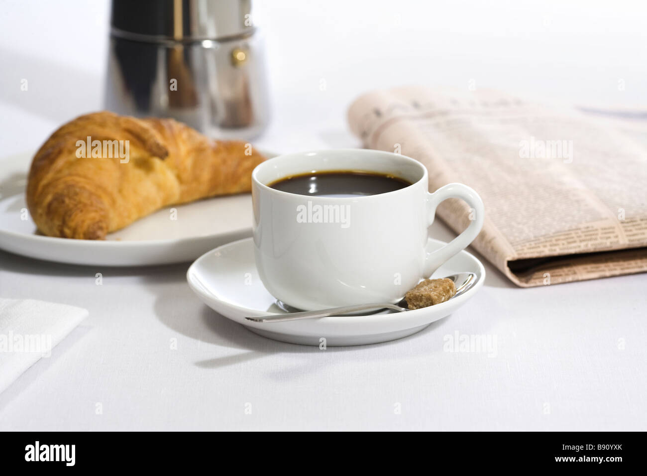 Cup of coffee a newspaper and a Danish pastry Sweden Stock Photo Alamy
