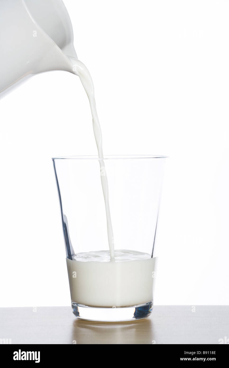 Milk being poured into a glass Stock Photo Alamy