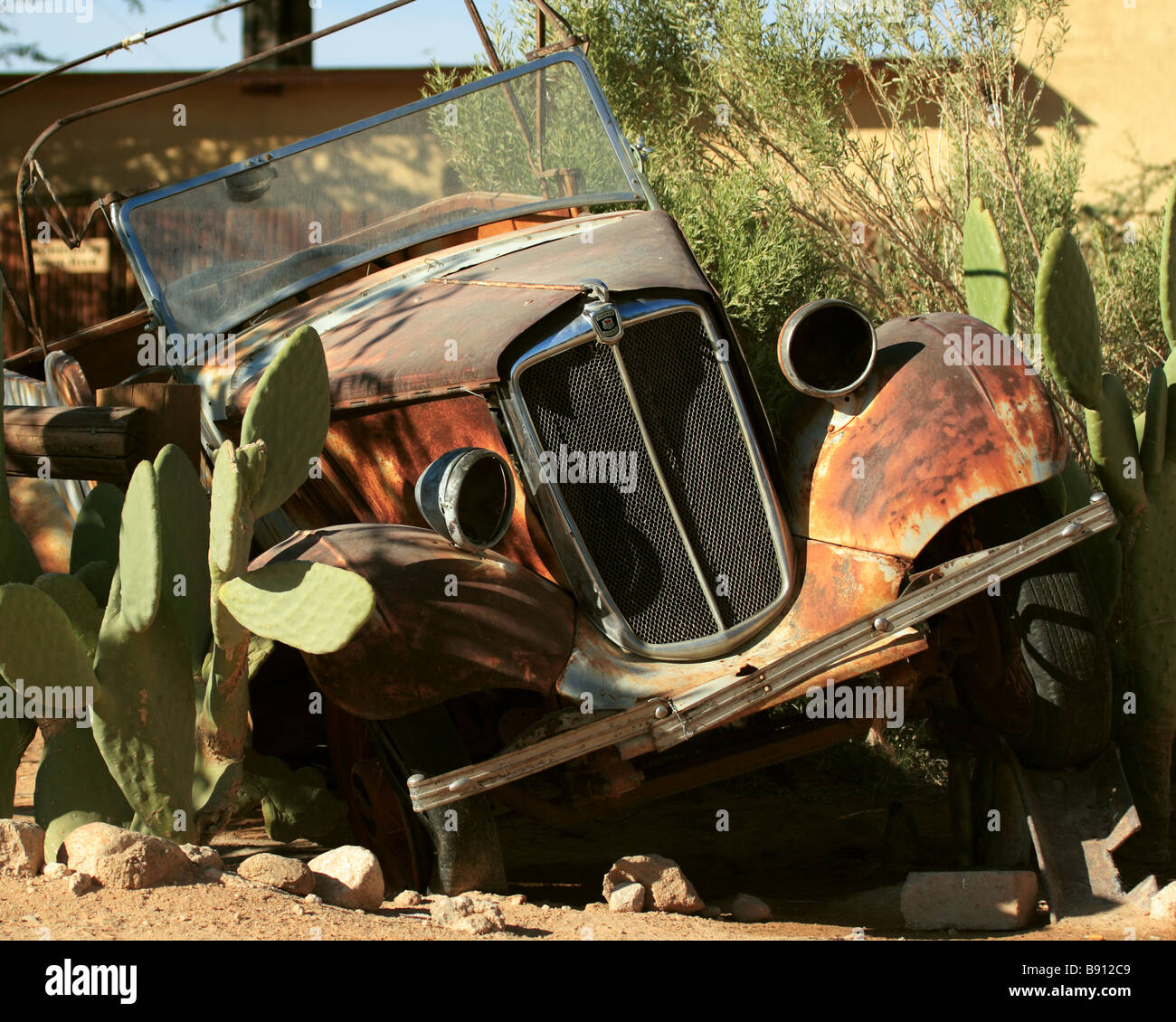 Old Morris 8 Wreck at Namibian Gas Station Stock Photo