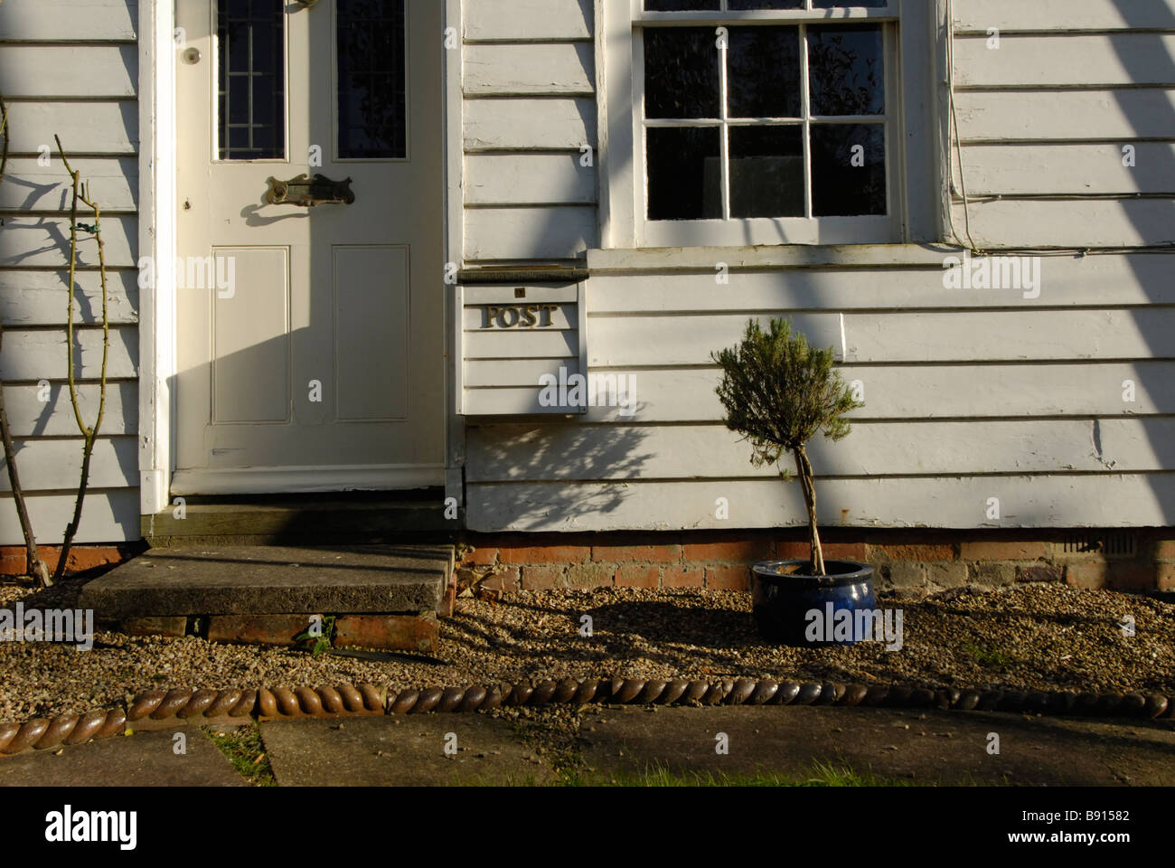 old white wooden clapboard house front long shadows in Battle East Sussex Stock Photo