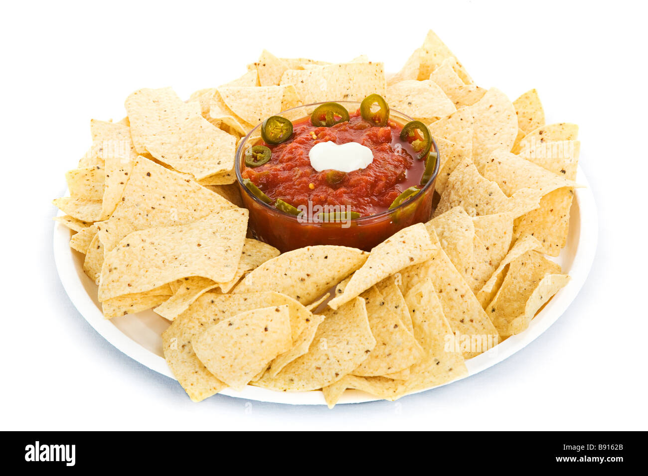 Tortilla chips and salsa with jalapeno peppers and sour cream isolated